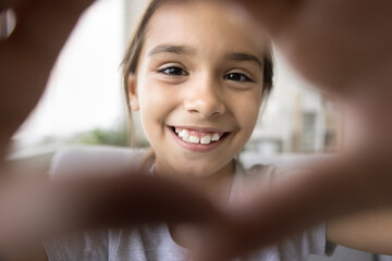Close up webcam view beautiful face of little Hispanic kid girl smiling joined their fingers...