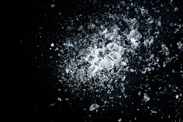 Ice, crushed on black background. Shards of crushed ice spreading away. The explosion of ice.