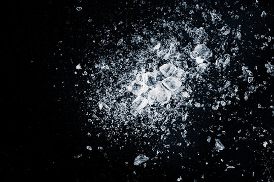 Ice, crushed on black background. Shards of crushed ice spreading away. The explosion of ice.