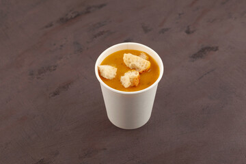 Lentil Soup Mercimek Çorbası with crispy wheat croutons in disposable paper cup. Street fast food. Take away food and drink concept. Traditional Turkish cuisine