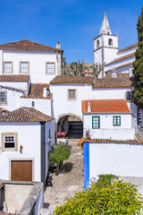 Fototapeta premium Portugal, Obidos. Small church steeple and homes.