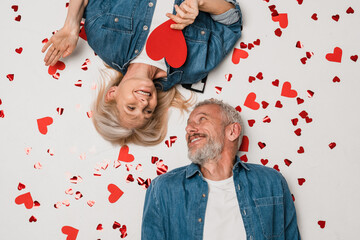 Top view of mature middle age couple family elderly gray-haired man blonde woman lying isolated...