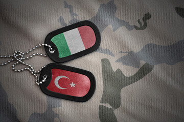 vintage army blank, dog tag with flag of italy and turkey on the khaki texture background. military...