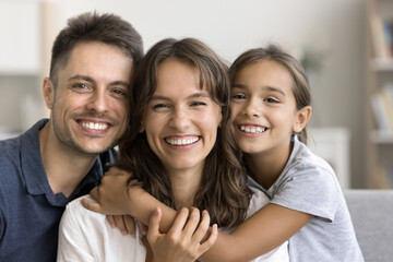 Authentic beautiful Latin parents and daughter smiling revealing white teeth advertise professional...