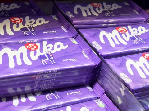 Stacks of milka alpenmilch chocolate bars with purple packaging