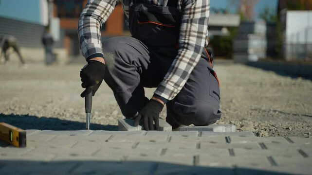 Worker Hammering Paving Stones in a Country Cottage Town