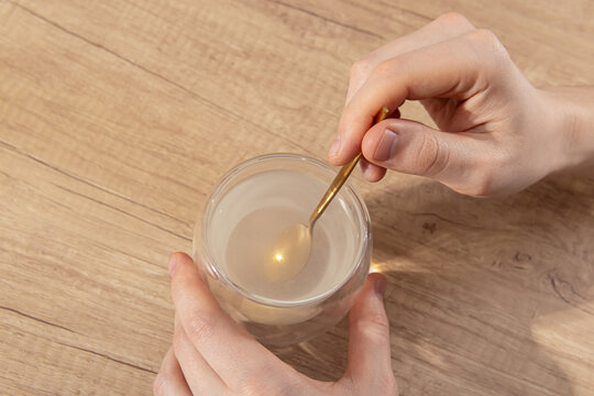 Man is stirring powder in glass of water with spoon. Vitamins or medicine. Men's health