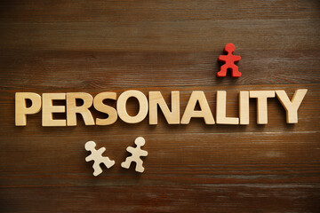 Word Personality made of letters and human figures on wooden table, top view