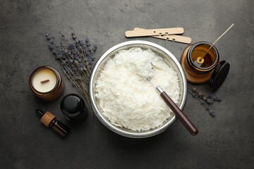 Soy wax and other supplies for making candles on grey table, flat lay