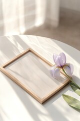 Fototapeta premium Minimalist frame rests on table beside delicate purple flower, e