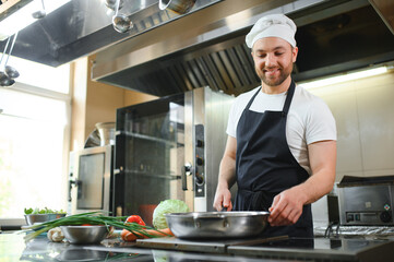 Chef cook in uniform cooking in the big cooker at the restaurant kitchen
