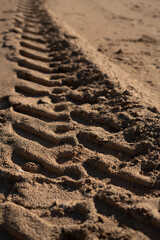 photo Image of deep tire tracks imprinted on sandy terrain showcasing detailed pattern and texture reflecting off-road vehicle movement and environmental interaction