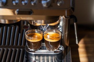 Two glasses of freshly brewed espresso coffee with crema made by an espresso machine