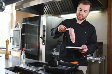 Chef cook in uniform cooking in the big cooker at the restaurant kitchen