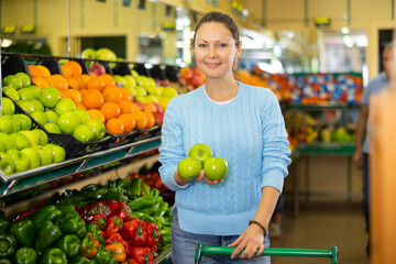 woman chooses fresh and sweet apples in farm shop