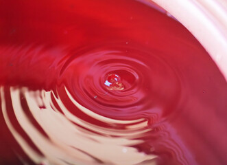 Close-Up of Red Liquid Surface with Ripple Pattern