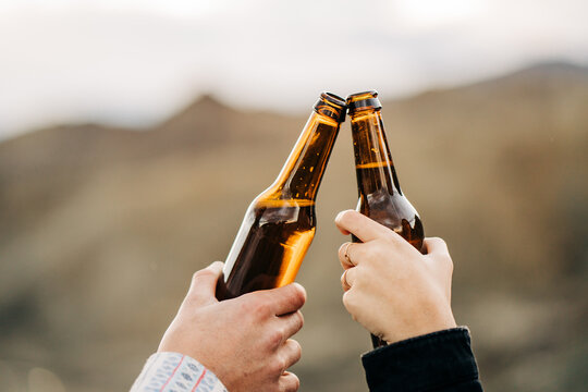 Tourists toasting with beer bottles enjoying camper van life