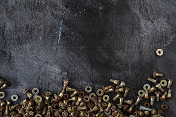 Top Down Aerial View of Rusty Bolts and Washers on a Textured Dark Surface with Empty Space for Text or Content – Industrial Hardware Background