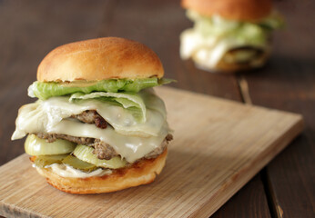 Two turkey burgers on wooden board, close up