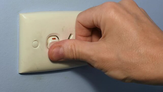 240 volt power point outlet man’s hand unplugging lead cord repeatedly switching switch off and on and off Obsessive Compulsive Disorder OCD concept 