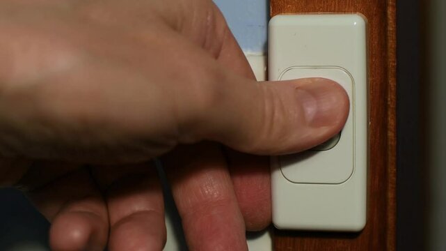240 volt light switch man&rsquo;s hand repeatedly switching switch off and on and off Obsessive Compulsive Disorder OCD concept