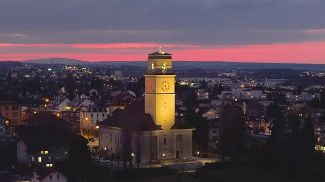 Mountains loom over a picturesque town near a serene lake at sunset in Arbon. Switzerland