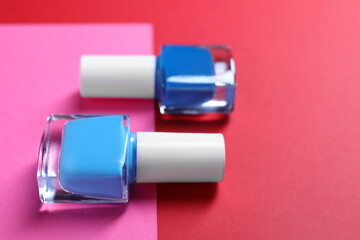 Nail polishes in bottles on color background, closeup. Space for text