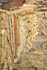 Layers of repaired walls in ancient Ephesus. A close-up of layered wall repairs in the historical settlement of Ephesus, showcasing aged plaster, stone, and faded fresco remnants over time.  

