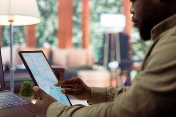 Business owner conducting strategic research on office spaces and building layouts, using blueprints and sketches to draft and organize a new corporate creative workspace. Office hunt relocation.