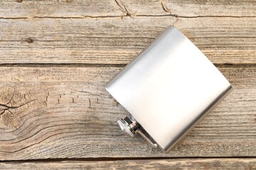 One hip flask on wooden table, top view. Space for text