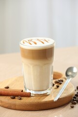 Tasty latte macchiato in glass on wooden table, closeup