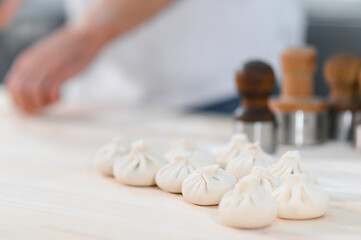 Khinkali, dumplings, meat in the dough cooking with hands. large. Juicy meat in a dough with spicy herbs to dab in hands. Tasty hot Georgian, Eastern, dish.
