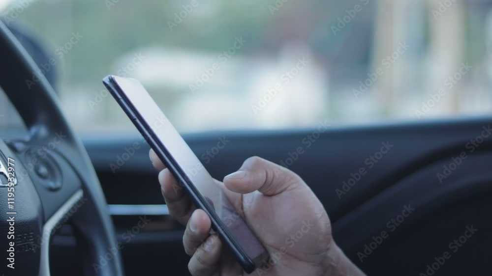 Poster B roll - Closeup of man hand using smartphone while seated comfortably inside a car. A person using a mobile phone to check email for work or text SMS messages. Online business communication concept.