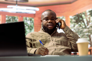 Startup entrepreneur calling his investors group from home office setup to negotiate business funds for development. Administrator discussing with people on important phone call.