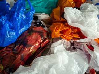 background of too many plastic bags on a domestic household table, harmful to the environment and causing pollution. Sustainability and waste from consumer spending, filling up cupboards in houses