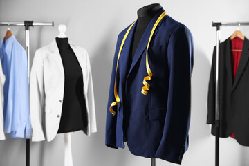 Male mannequin with jacket and measuring tape in tailor shop