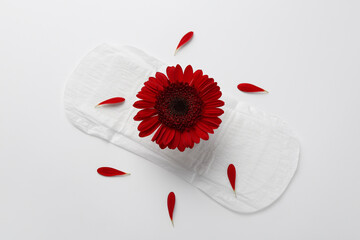 Menstrual pad with red flower on white background