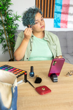 Transgender man creating makeup tutorial using mobile phone