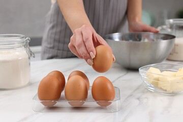 Making dough. Woman with fresh eggs at white marble table, closeup