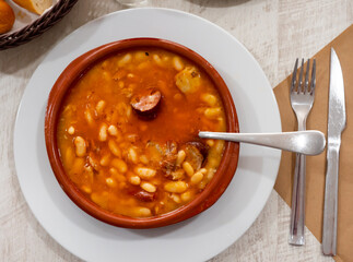 Tasty white bean stew with sausages in bowl, typical spanish dish