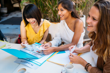 University exchange students organizing travel schedule together at cafe