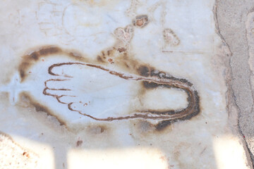 Ancient foot carving on weathered stone surface . A historic foot engraving on a weathered stone...