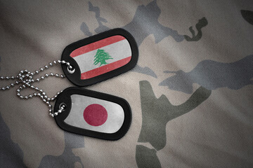 vintage army blank, dog tag with flag of lebanon and japan on the khaki texture background....
