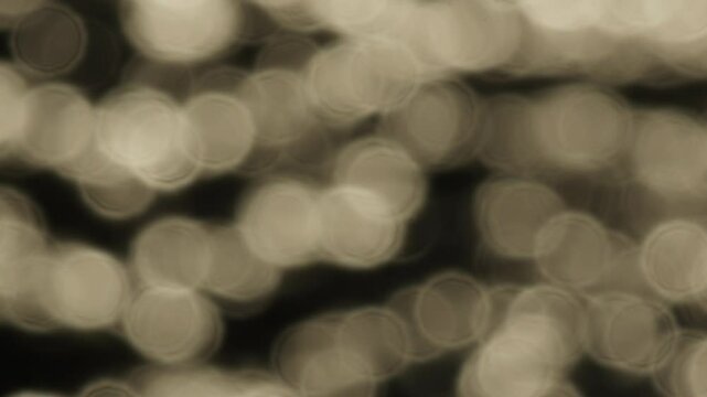 Blurred light boket sea at sunset or sunrise,Sun reflects and sparkles on waves with bokeh lights, Slow motion video nature background