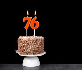 Birthday cake with number 76 candle - Anniversary card on a black background