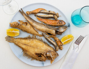 Delicious fried fish with lemon - flounder, sardines and other sea fish