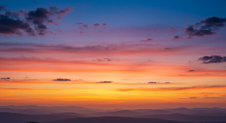 Fototapeta premium Breathtaking Sunset Over Rolling Hills and Mountains