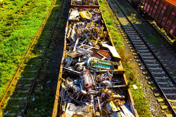 Above view of railway cargo train wagon filled by old rusty black metal scrap garbage forfactory plant recycling. Steel waste collecting, disposal transportation logistics. 