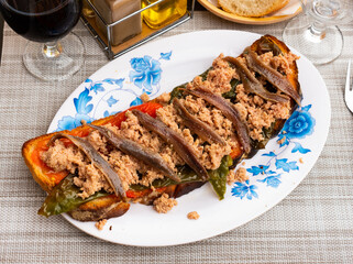 Delicious toast with shredded canned tuna, anchovies and roasted bell pepper slices. Mediterranean...
