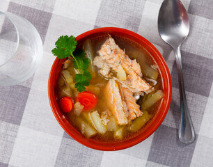 Appetizing salmon offal soup with vegetables - potatoes, carrots and parsley